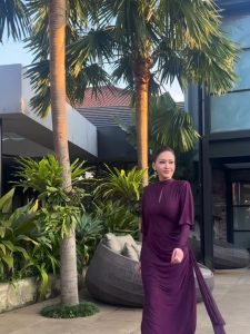 Di momen istimewa tersebut, Maia tampil memukau mengenakan gaun panjang berwarna ungu gelap rancangan Olive & Hers. Gaun ini dihiasi taburan kristal Swarovski yang menyebar merata, menciptakan efek kilau dramatis saat tersorot cahaya. Pilihan warna yang kaya dan detail berkilau memberi sentuhan glamor tanpa terkesan berlebihan.